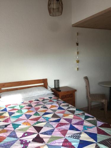a bedroom with a colorful quilt on a bed at Es volca in Cadaqués