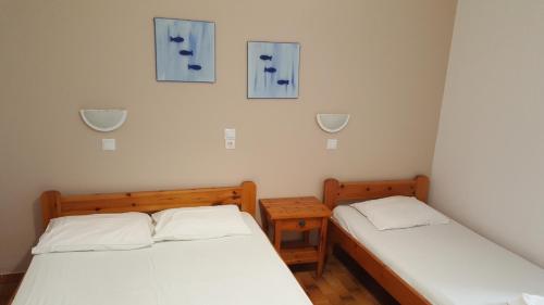 パリキアにあるAratos Hotelの青い絵が壁に飾られた客室のベッド2台