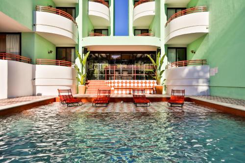 聖安東尼奧的住宿－Cubanito Ibiza，水中带椅子的建筑中的游泳池