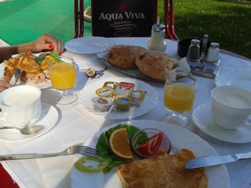 a table with plates of food and glasses of orange juice at B&B Vila Vidikovac in Arandjelovac