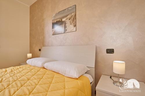 sypialnia z łóżkiem z żółtą narzutą w obiekcie Appartamento Romantica w Manerba del Garda