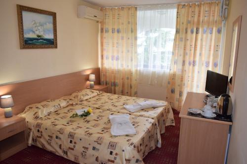a hotel room with a bed with flowers on it at Ahilea Hotel - Free Pool Access in Balchik