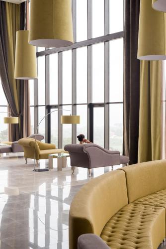 a living room with yellow furniture and large windows at Vila Gale Collection Sintra in Sintra