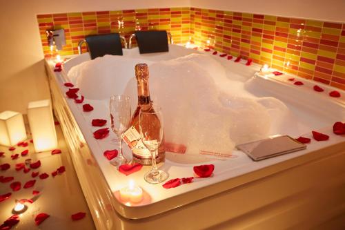 uma banheira com uma garrafa de champanhe e rosas em Hotel Zona A em Medellín