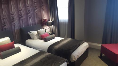 a hotel room with two beds and a window at Grey Street Hotel in Newcastle upon Tyne