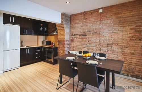 a kitchen with a dining table and a brick wall at Alcam Alio 1 in Barcelona