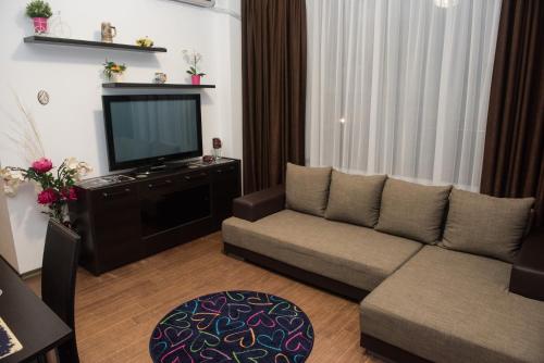 - un salon avec un canapé et une télévision dans l'établissement 21 by the Sea, à Mamaia