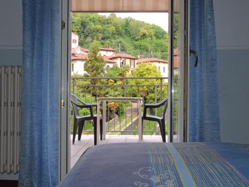 a bedroom with a view of a balcony with two chairs at Hotel Capri in Lesa