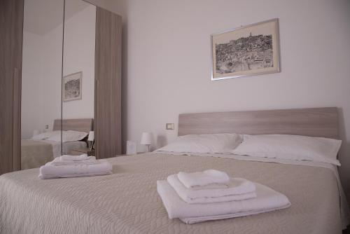 a white bed with two towels on top of it at Casa vacanza " I due Angeli " in Matera