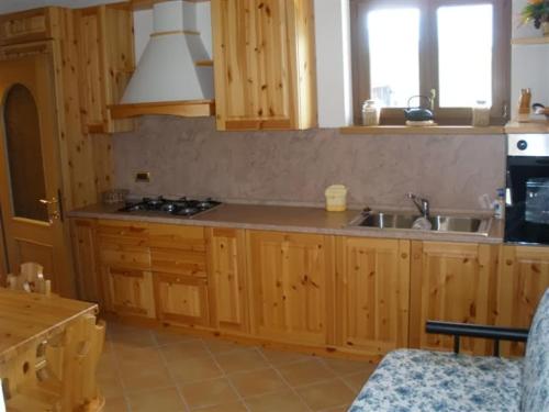 a kitchen with wooden cabinets and a sink at APPARTAMENTI in Villa Isabella in Bianzone