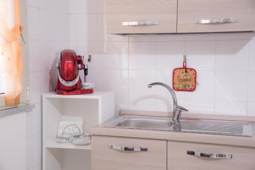 a kitchen with a sink and a red appliance at Casa vacanza " I due Angeli " in Matera