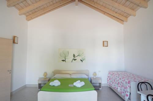 a bedroom with a bed with a green blanket at Il Giardino Del Tiglio in Uggiano la Chiesa