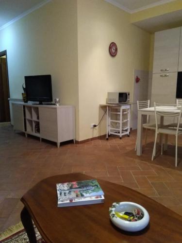 a living room with a table and a tv at Casa Vacanze Le Rose in Ariccia