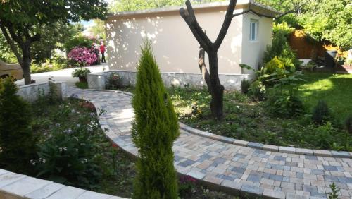 a garden with a brick walkway in front of a house at Riverside Guesthouse in Počitelj