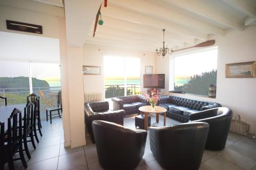un salon avec des canapés, une table et des chaises dans l'établissement Villa le Rayon Vert, à Saint-Pierre-en-Port