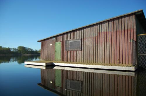 a building on a body of water at Auf dem Berg in Malchow