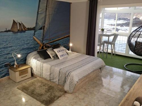 1 dormitorio con 1 cama con un velero en el agua en Apartment on the sea, en Puerto de la Madera