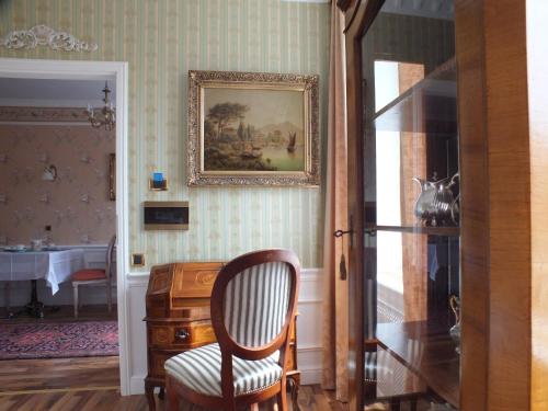 a room with a chair and a picture on the wall at Villa-Angelina in Langenzersdorf