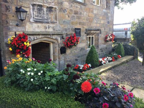 a garden of flowers in front of a stone building at Hurstwood Hall in Burnley