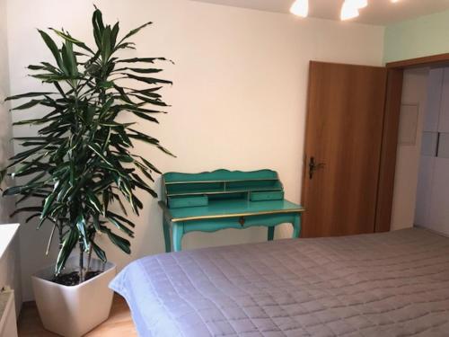 EigeltingenにあるFewo Metzgerのベッドルーム1室(ベッド1台、緑のテーブル、植物付)