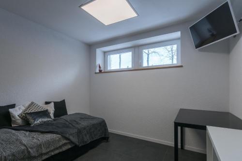 a bedroom with a bed and a window at La Ferme des Arêtes in La Chaux-de-Fonds