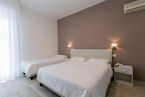 a hotel room with two beds and a window at Hotel Saviola in Sirmione