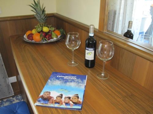 a table with two wine glasses and a magazine at Hotel Panoramic in Giardini Naxos