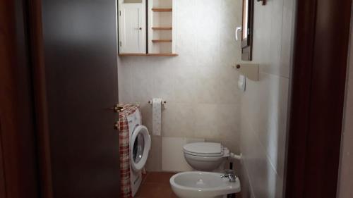 un piccolo bagno con un water e un lavandino di Appartamenti I Mandorli a Budoni
