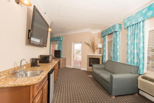 a bathroom with a sink and a couch in a room at Amelia Hotel at the Beach in Fernandina Beach