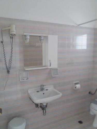 a bathroom with a sink and a toilet and a mirror at ΑRILLA STUDIOS in Perdika
