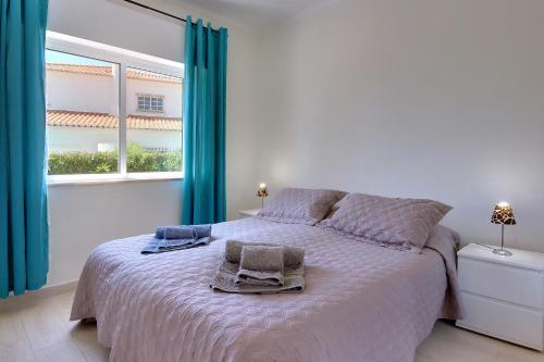 ein Schlafzimmer mit einem Bett mit zwei Handtüchern darauf in der Unterkunft Casa Silver in Carvoeiro