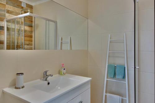 ein Bad mit einem Waschbecken und einer Dusche mit einem Spiegel in der Unterkunft Casa Silver in Carvoeiro