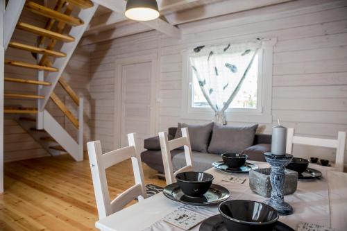a dining room with a table and chairs and a couch at biale domki in Pobierowo
