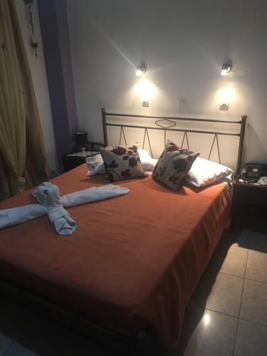 a large bed with two stuffed animals on it at Hotel George in Kalamata