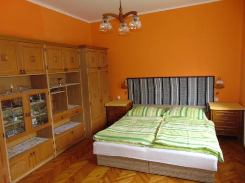 a bedroom with a bed and some wooden cabinets at Székely Apartman in Balatonfüred