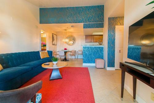 a living room with a blue couch and a red rug at Luxury Modern Condo 2 in Las Vegas