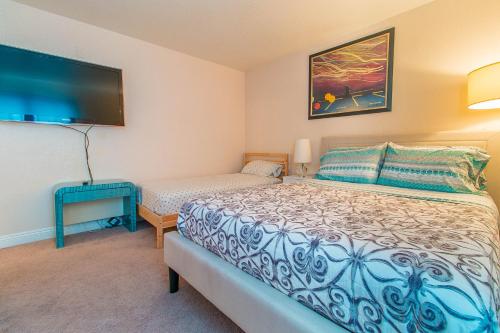 Un dormitorio con una cama y un televisor de pantalla plana. en Luxury Modern Condo 2, en Las Vegas