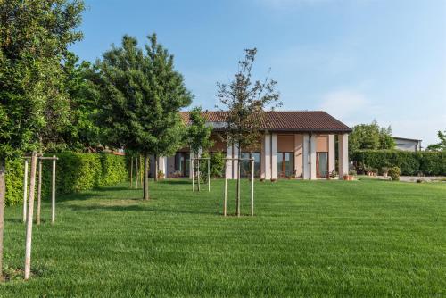 a house with trees in front of a yard at Agriturismo Ca' Giulietta in Sommacampagna