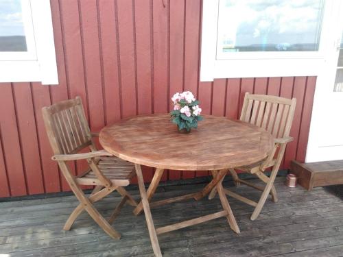 een houten tafel met twee stoelen en een vaas met bloemen erop bij Sunne Stugcenter 18 in Gräsmark