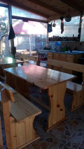 a large wooden table and benches in a kitchen at Matev Hotel in Burgas