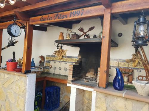 una cocina con chimenea y reloj. en Ca la Pilar, en El Poblenou del Delta