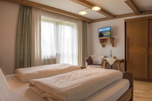 a hotel room with two beds and a window at Pension Anneliese in Schwendt