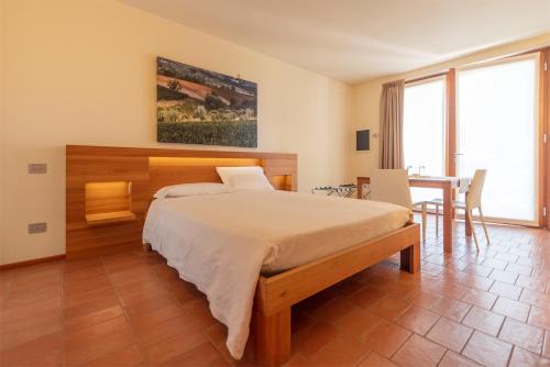 a bedroom with a large bed and a table and chairs at Agriturismo Ca' Giulietta in Sommacampagna