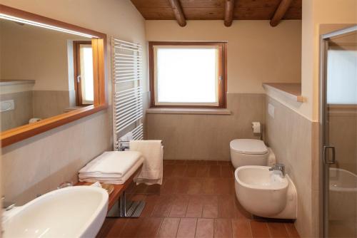 a bathroom with two sinks and a toilet and a window at Agriturismo Ca' Giulietta in Sommacampagna
