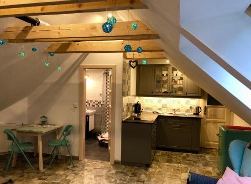 an attic kitchen with a counter and a table at Guest House K74 in Jablonné v Podještědí