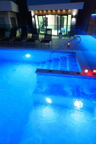 a large blue pool with lights in a building at Boutique Apartments Ad Astra in Bibinje
