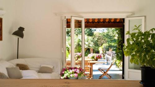 uma sala de estar com um sofá branco e uma porta de vidro deslizante em Nakato em Fréjus
