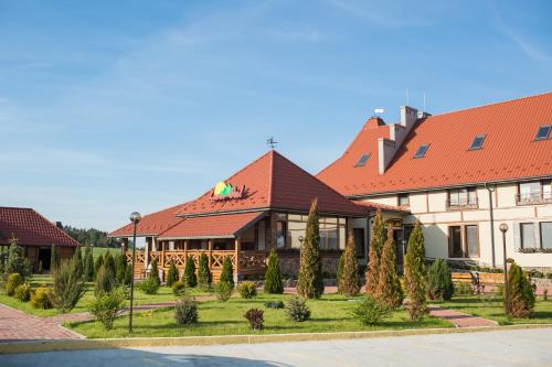 a large building with red roofs and trees at Hotel & Restaurant Complex HAP-OK in Brodki