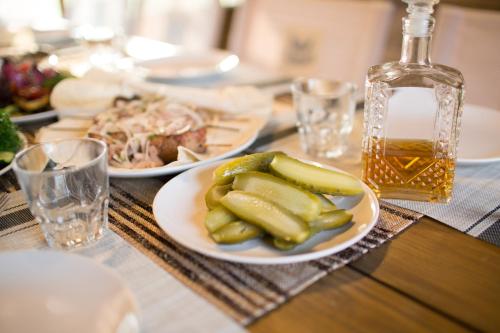 a table with plates of food and a bottle of whiskey at Hotel & Restaurant Complex HAP-OK in Brodki