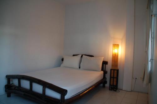 a small bed in a room with a light at Lamphuhouse Bangkok in Bangkok